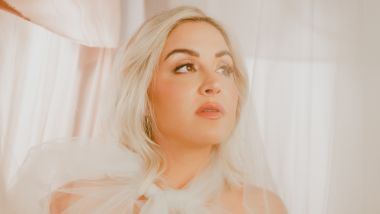 Maggie Rose dressed in white with white background