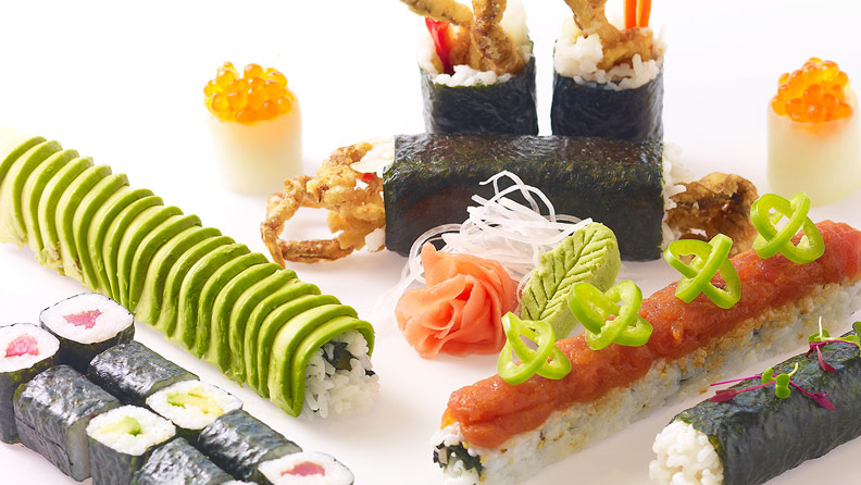 different sushi rolls displayed on a white surface