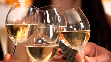 four glasses of white wine clinking