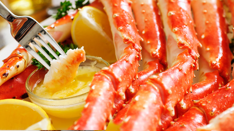 crab legs being dipped in butter